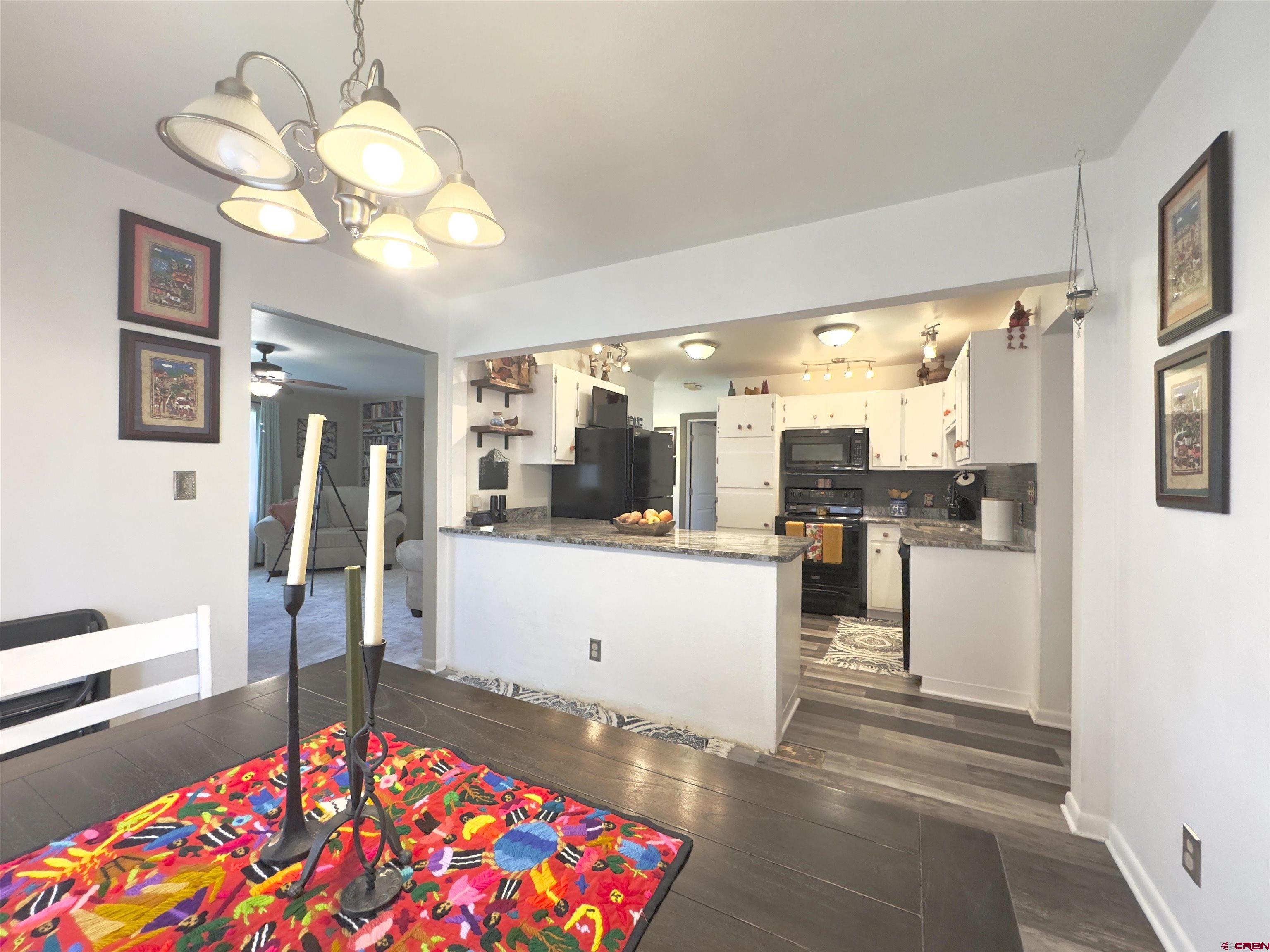 660 Columbia Avenue Del Norte, CO 81132 - Photo 10 of 31 a living room with kitchen island furniture and a chandelier