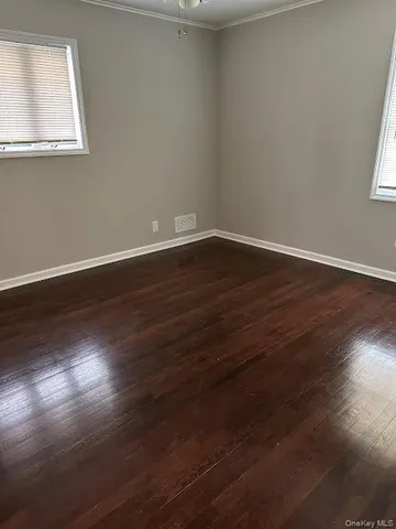 a view of a room with wooden floor and windows