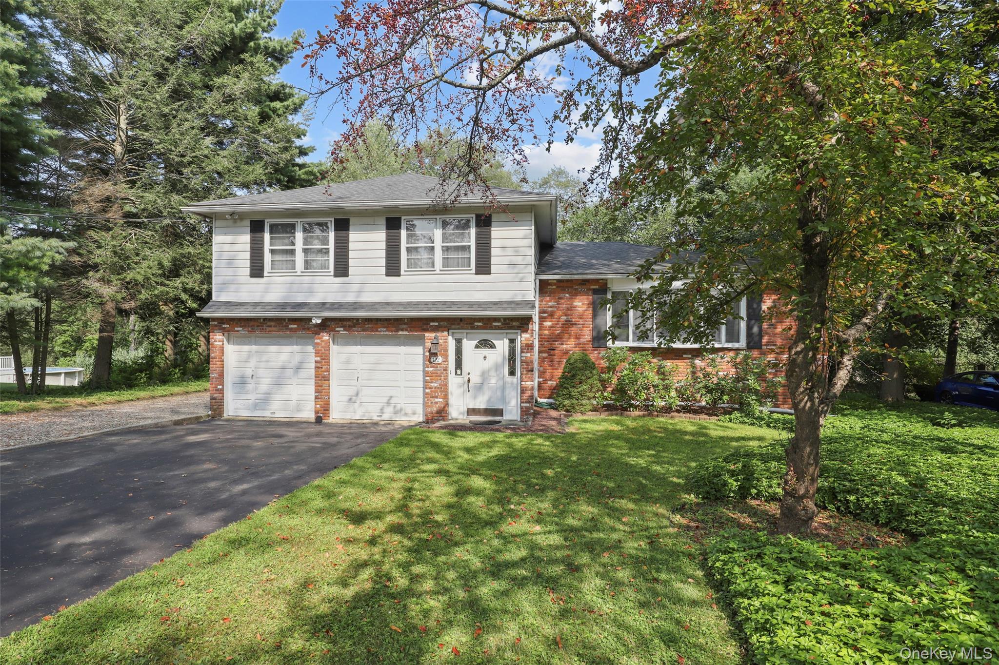 122 Fairmont Road Mahopac, NY 10541 - Photo 1 of 1 Split level home with brick siding, a garage, driveway, a front yard, and a shingled roof