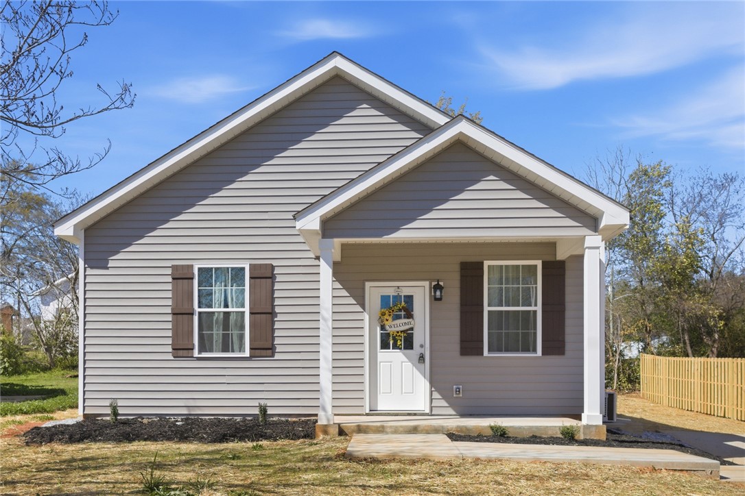 This charming home offers a cozy front porch, inviting you into comfortable living.