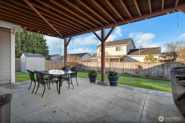 a view of a patio with a table chairs and a backyard