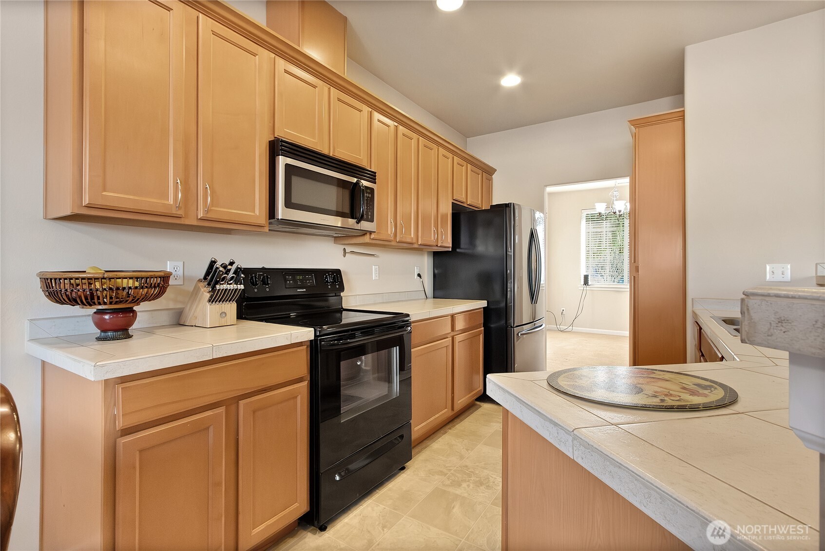 509 Balmer Street Southwest Orting, WA 98360 - Photo 8 of 22 a kitchen with stainless steel appliances granite countertop a sink a stove a refrigerator a washer and dryer