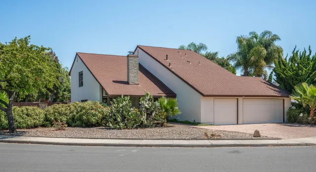 a house with a yard and a car parked in front of it
