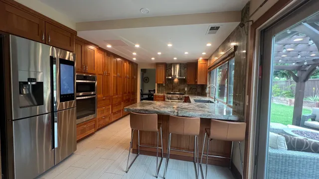 a kitchen with stainless steel appliances granite countertop a refrigerator and a sink