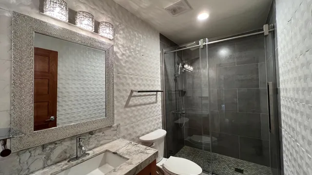 a bathroom with a shower toilet and sink