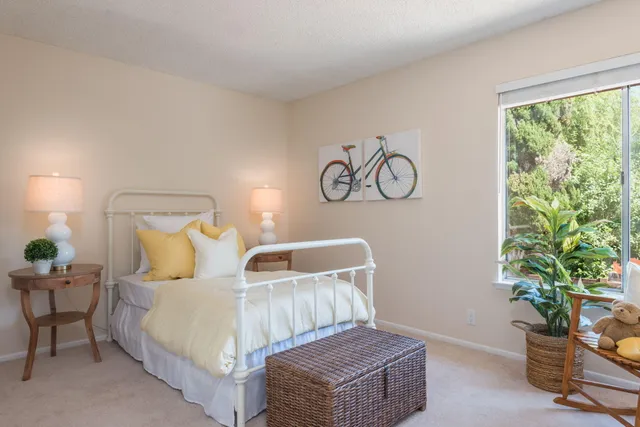 a bedroom with a large bed and a potted plant