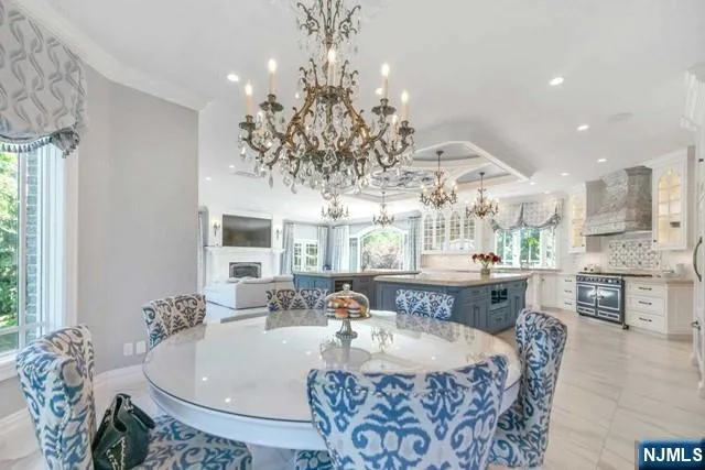 a view of a dining room and livingroom with furniture wooden floor a chandelier