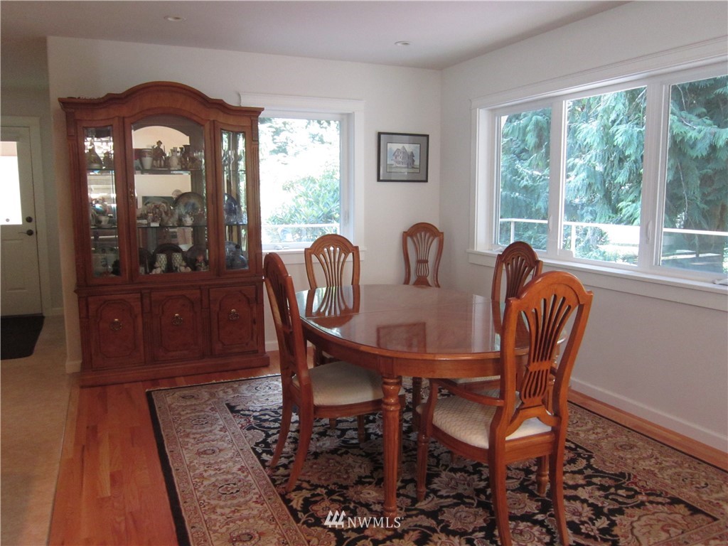 3540 7075 South Clinton, WA 98236 - Photo 6 of 25 a dining room with furniture wooden floor a rug a potted plant and a chandelier