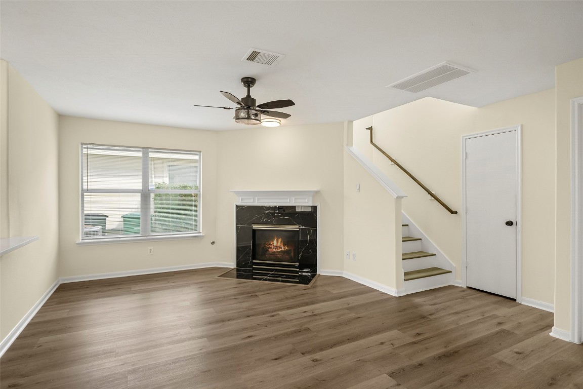 13226 Ridgewood Knoll Lane Houston, TX 77047 - Photo 13 of 37 a view of an empty room with wooden floor fireplace and a window