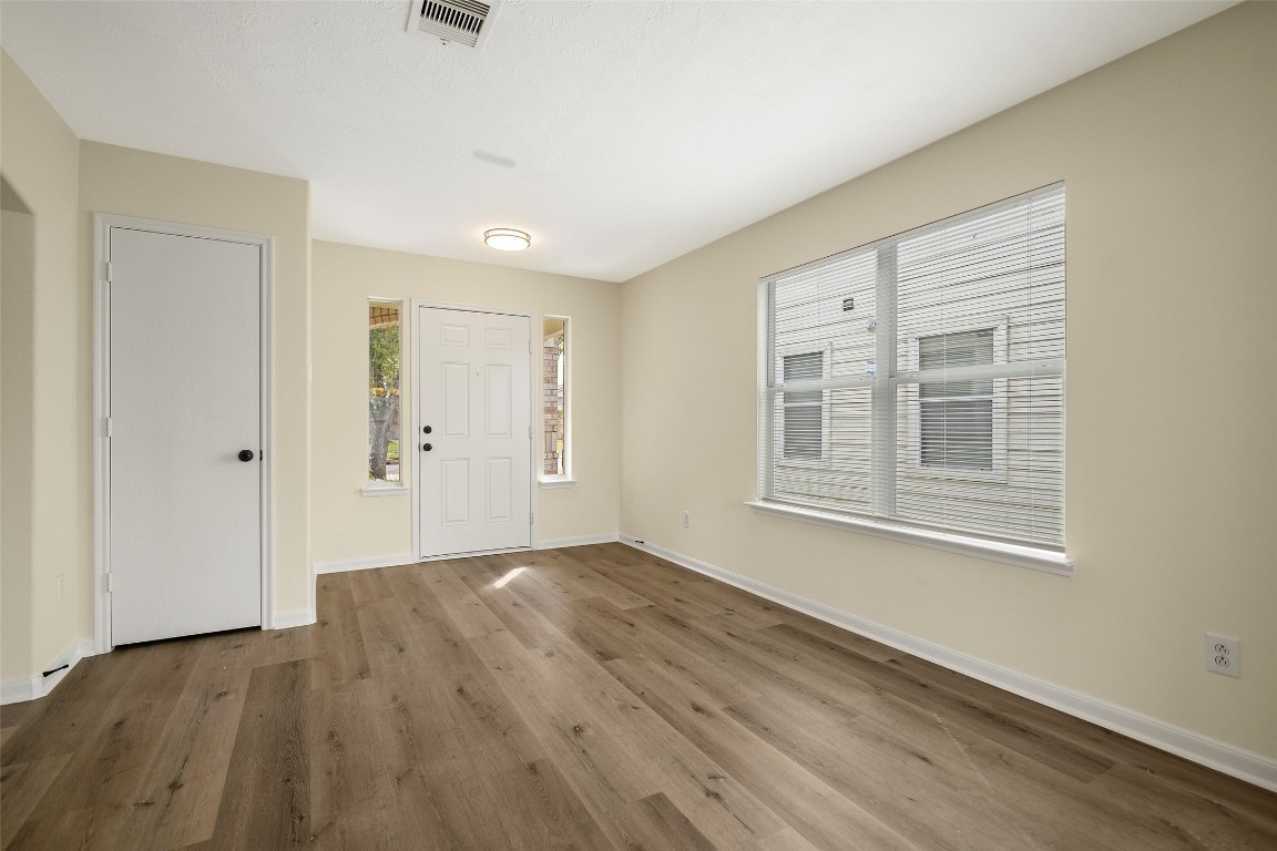 13226 Ridgewood Knoll Lane Houston, TX 77047 - Photo 14 of 37 a view of an empty room with wooden floor and a window