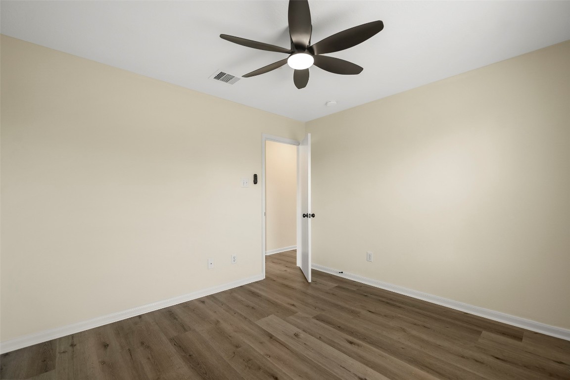 13226 Ridgewood Knoll Lane Houston, TX 77047 - Photo 25 of 37 an empty room with wooden floor and ceiling fan