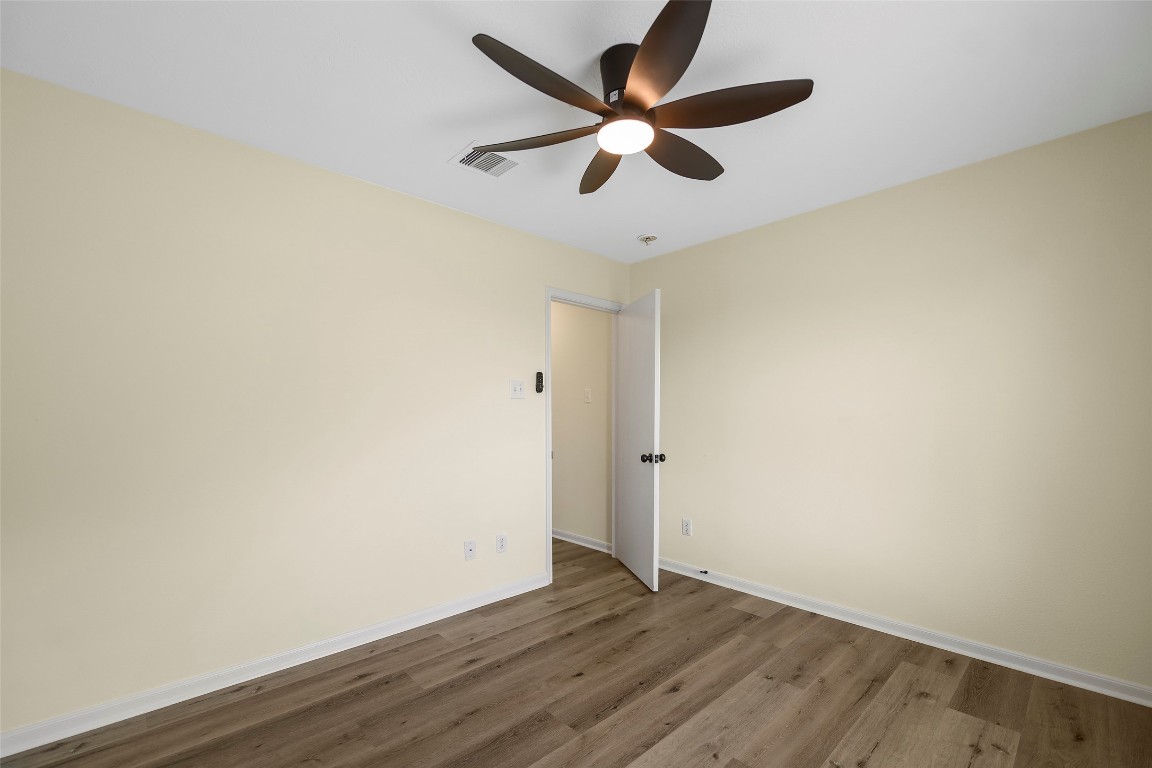 13226 Ridgewood Knoll Lane Houston, TX 77047 - Photo 28 of 37 an empty room with wooden floor and ceiling fan