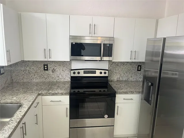 a kitchen with cabinets stainless steel appliances and a counter top