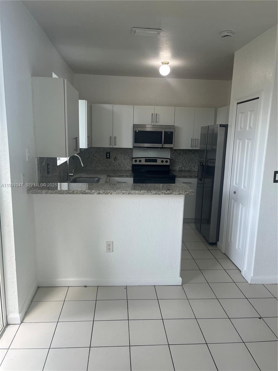 2508 Southeast 14th Avenue, Unit 287 Homestead, FL 33035 - Photo 5 of 17 a kitchen with stainless steel appliances a refrigerator sink and cabinets