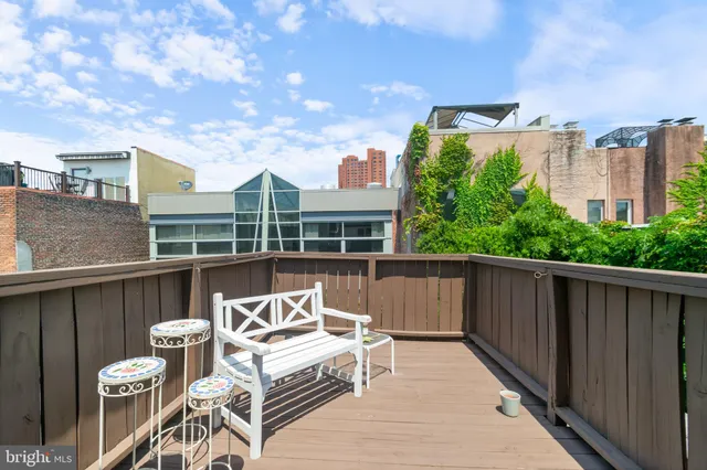 a view of a patio with table and chairs with wooden floor and fence