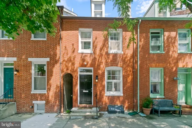 front view of a brick house with a yard