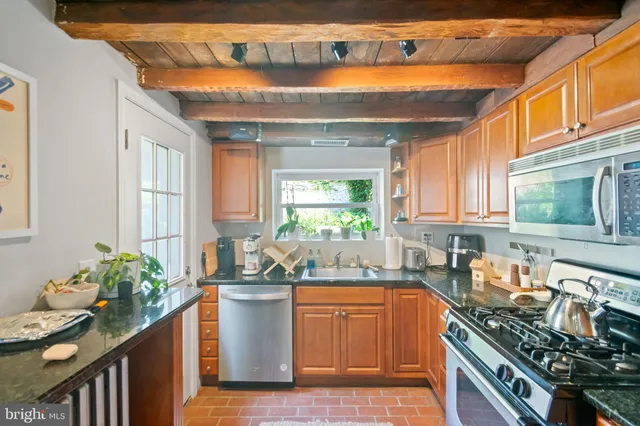 a kitchen with stainless steel appliances granite countertop a sink stove and cabinets