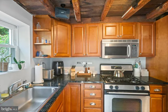 a kitchen with stainless steel appliances granite countertop a sink stove and cabinets
