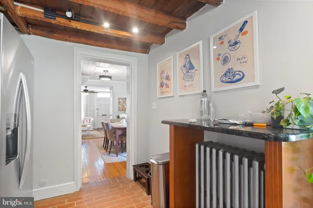 a hallway with painting on wall and a shower