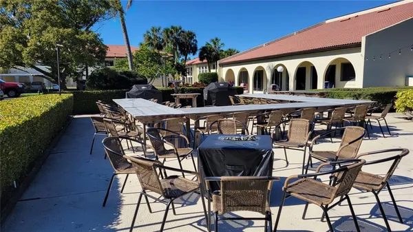 a view of a patio with table and chairs with plants and trees