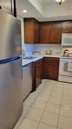 a kitchen with stainless steel appliances granite countertop a refrigerator a stove and a sink with wooden cabinets