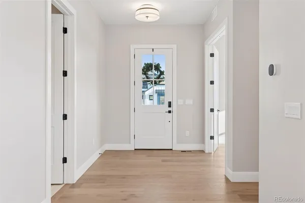 a view of a hallway with wooden floor and closet area