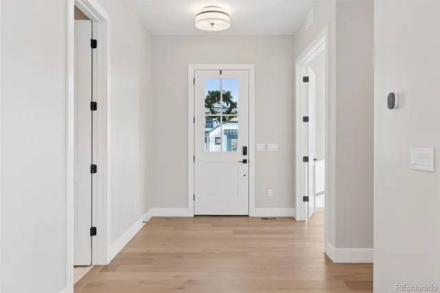 a view of a hallway with wooden floor and closet area