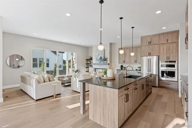 a large kitchen with stainless steel appliances kitchen island a large counter top a sink a stove and a refrigerator