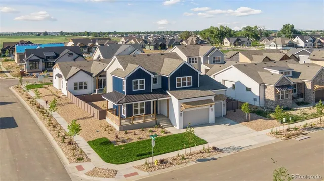 an aerial view of a house with a garden and parking space