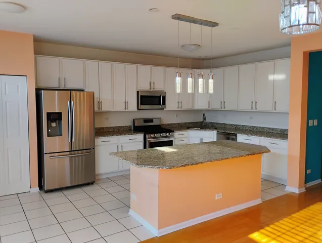 a kitchen with granite countertop a refrigerator and a sink