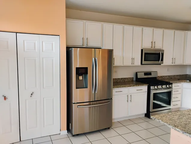 a kitchen with cabinets stainless steel appliances and a counter space