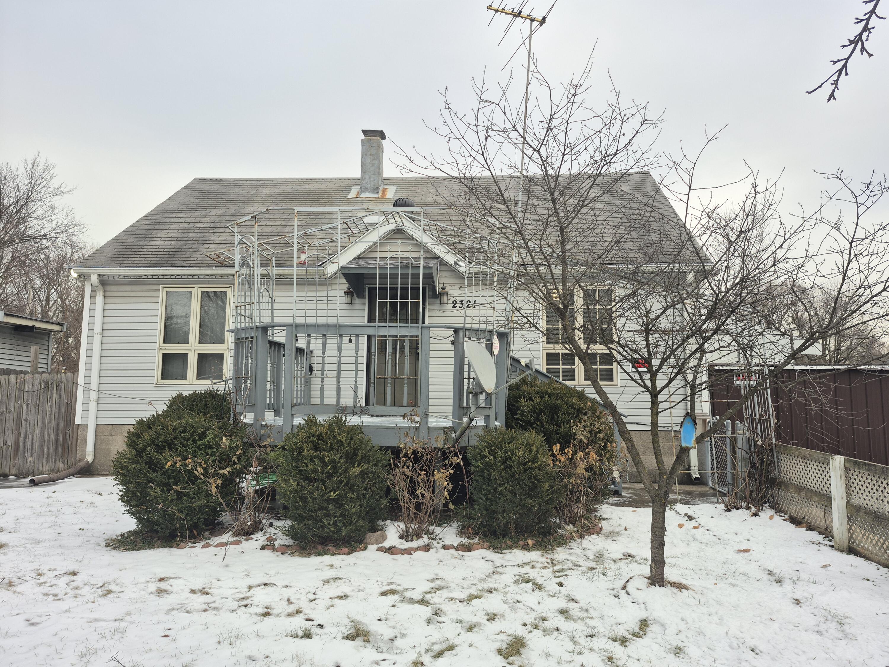 a front view of a house with a yard covered in snow