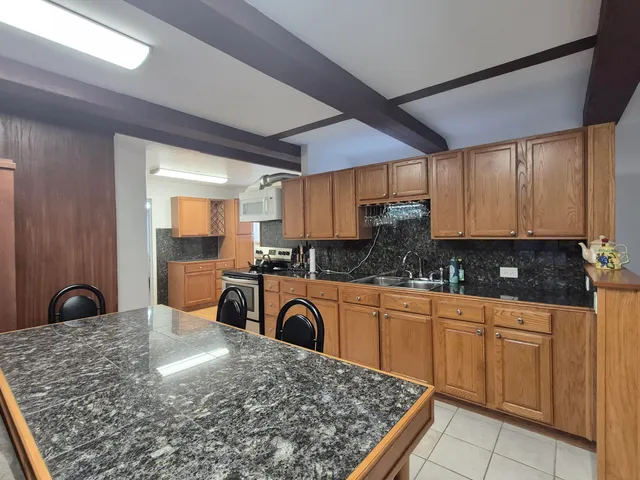 a kitchen with stainless steel appliances granite countertop a stove sink and cabinets