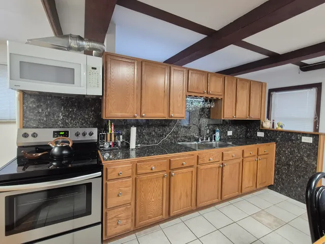 a kitchen with stainless steel appliances granite countertop a stove sink and cabinets