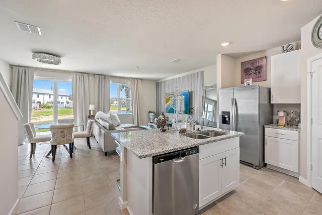 a kitchen with a sink refrigerator and cabinets