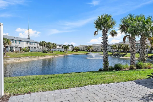 a view of a house with a yard and lake view