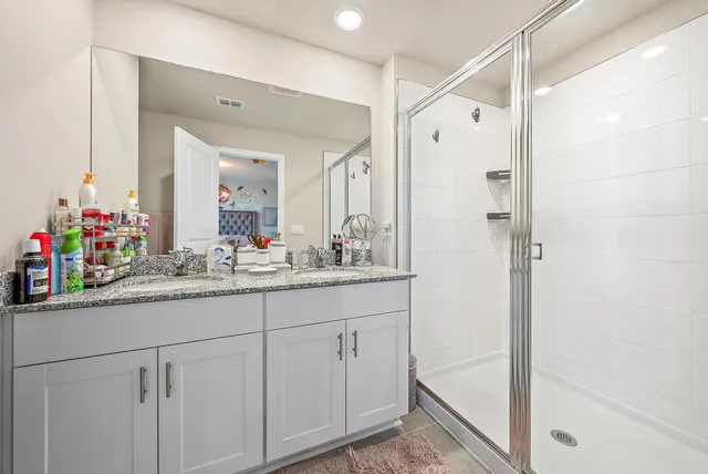 a bathroom with a shower sink and mirror