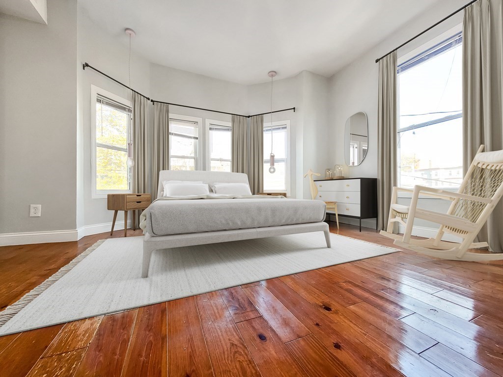 a spacious bedroom with a bed and wooden floor