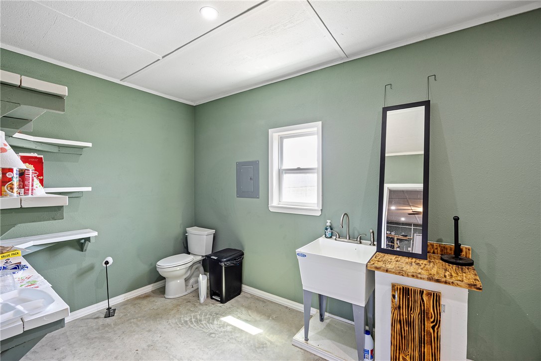 276 Charton Road Morrilton, AR 72110 - Photo 13 of 37 Utility room featuring a toilet, a utility sink with a faucet, and a wall-mounted electrical panel