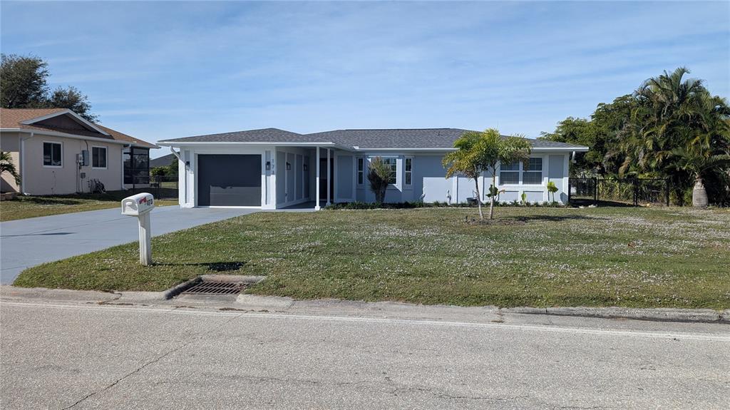 173 Rotonda Circle Rotonda West, FL 33947 - Photo 11 of 13 a front view of a house with a yard and garage