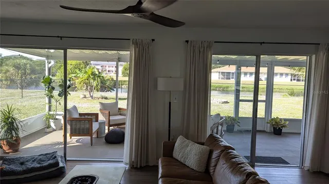 a living room with furniture and a floor to ceiling window