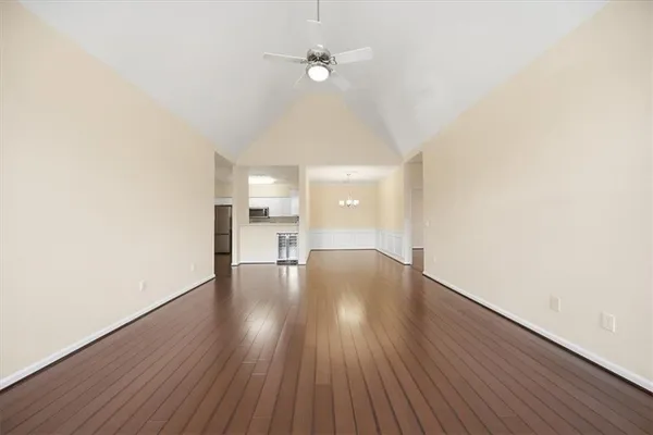 a hallway with wooden floor chandelier and entryway