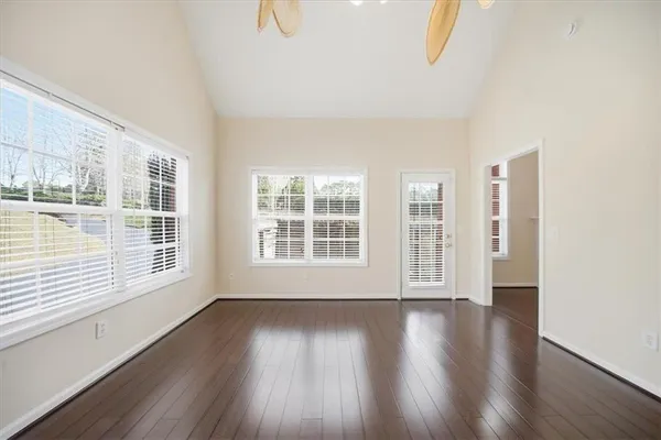 an empty room with wooden floor and windows