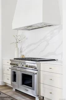 a stove top oven sitting inside of a kitchen