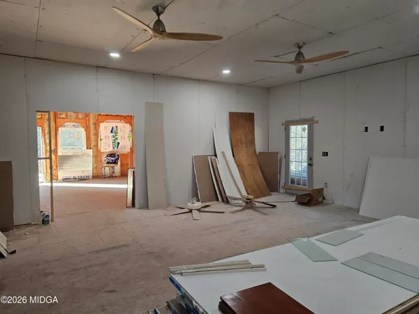 a living room with a bed furniture and a flat screen tv