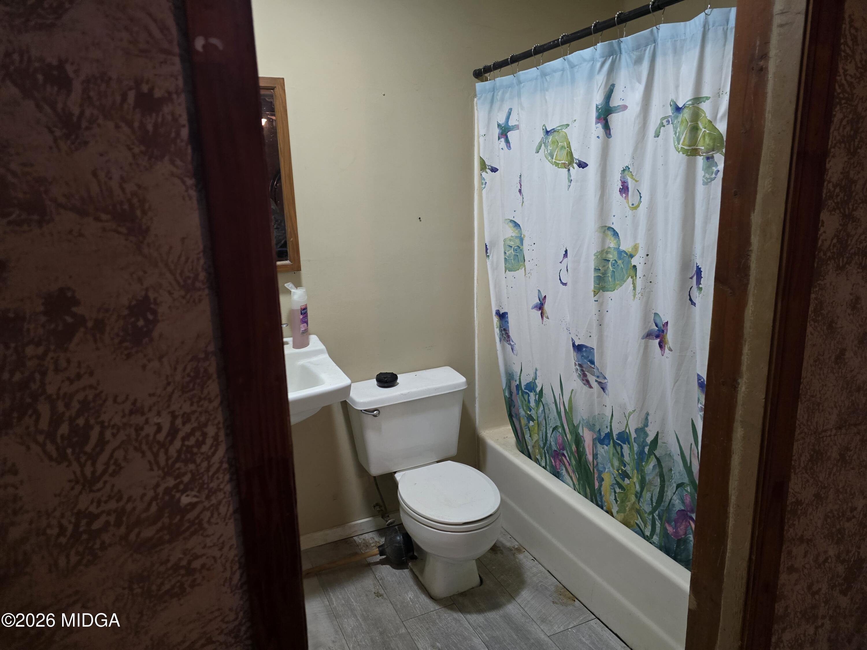 253 Pottery Road Lizella, GA 31052 - Photo 20 of 31 a white toilet sitting next to a shower curtain