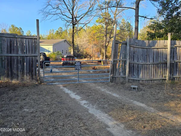 a view of a yard with wooden fence
