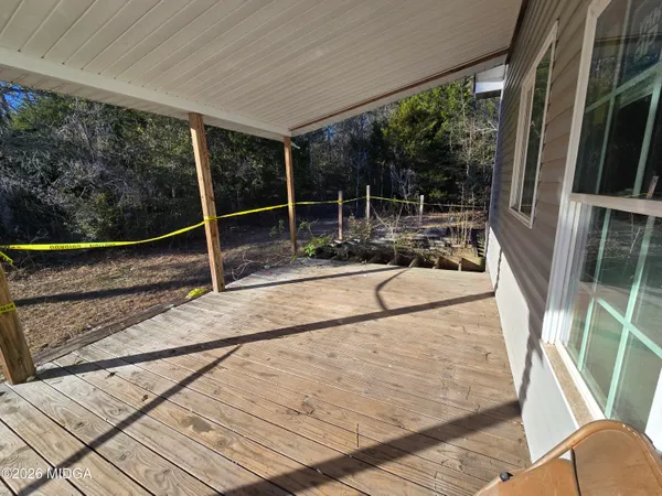 a backyard of a house with large trees and wooden fence