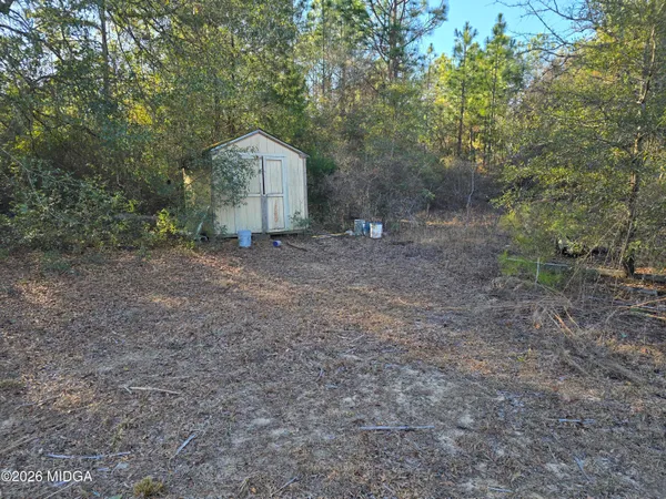 a backyard of a house with barbeque oven table and chairs
