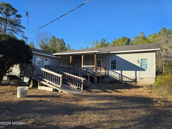 a view of a house with a yard and sitting area